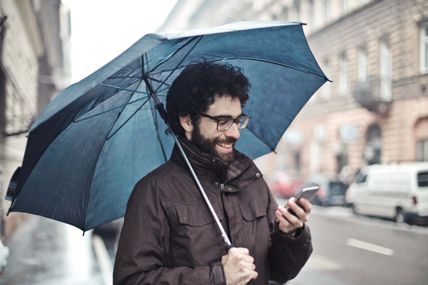 Man in plaid shirt smiles at child from car window.