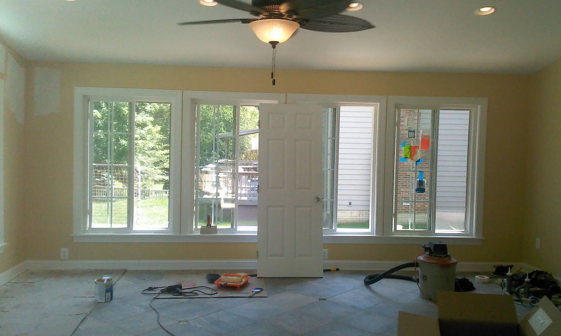 A room with a lot of windows and a ceiling fan