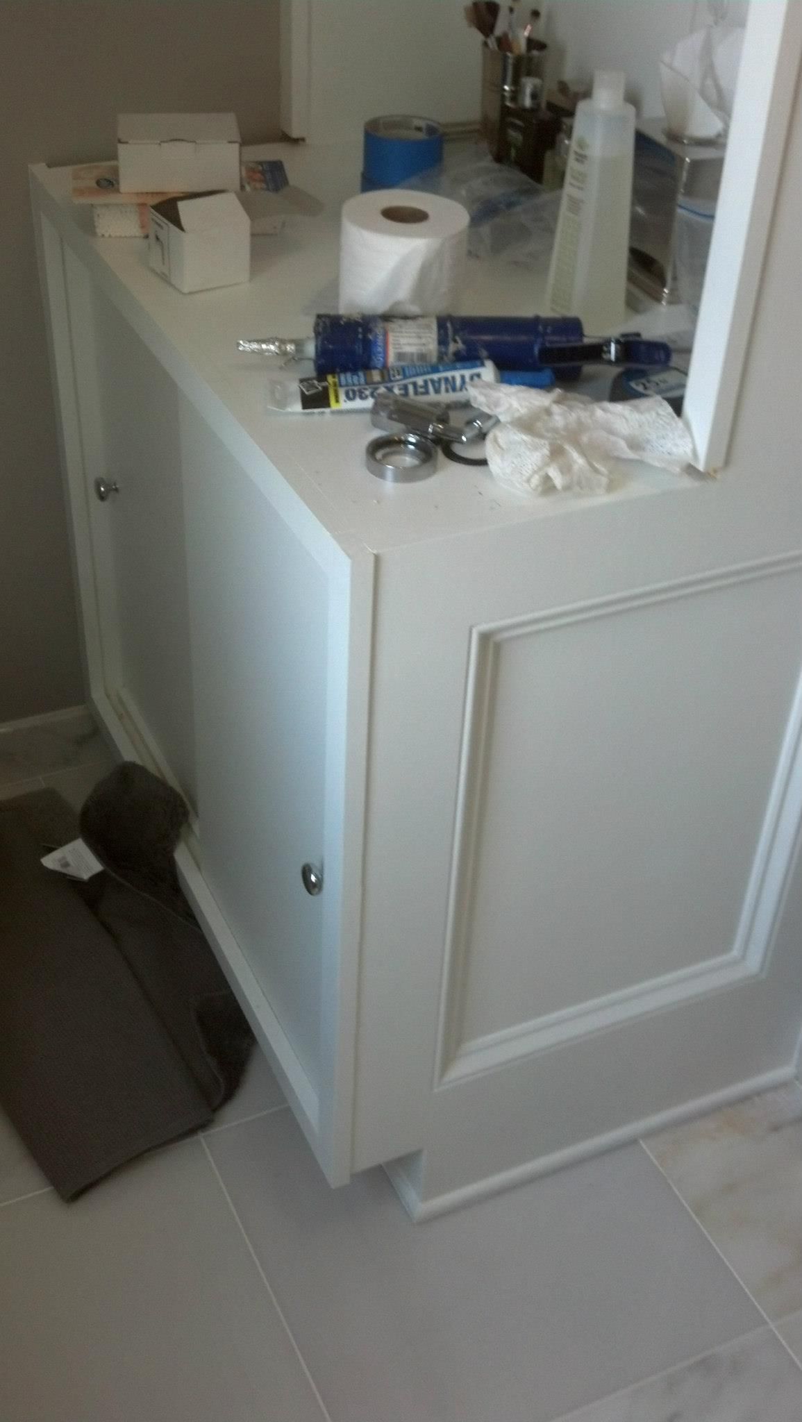 A bathroom vanity with a toilet paper roll on top of it.
