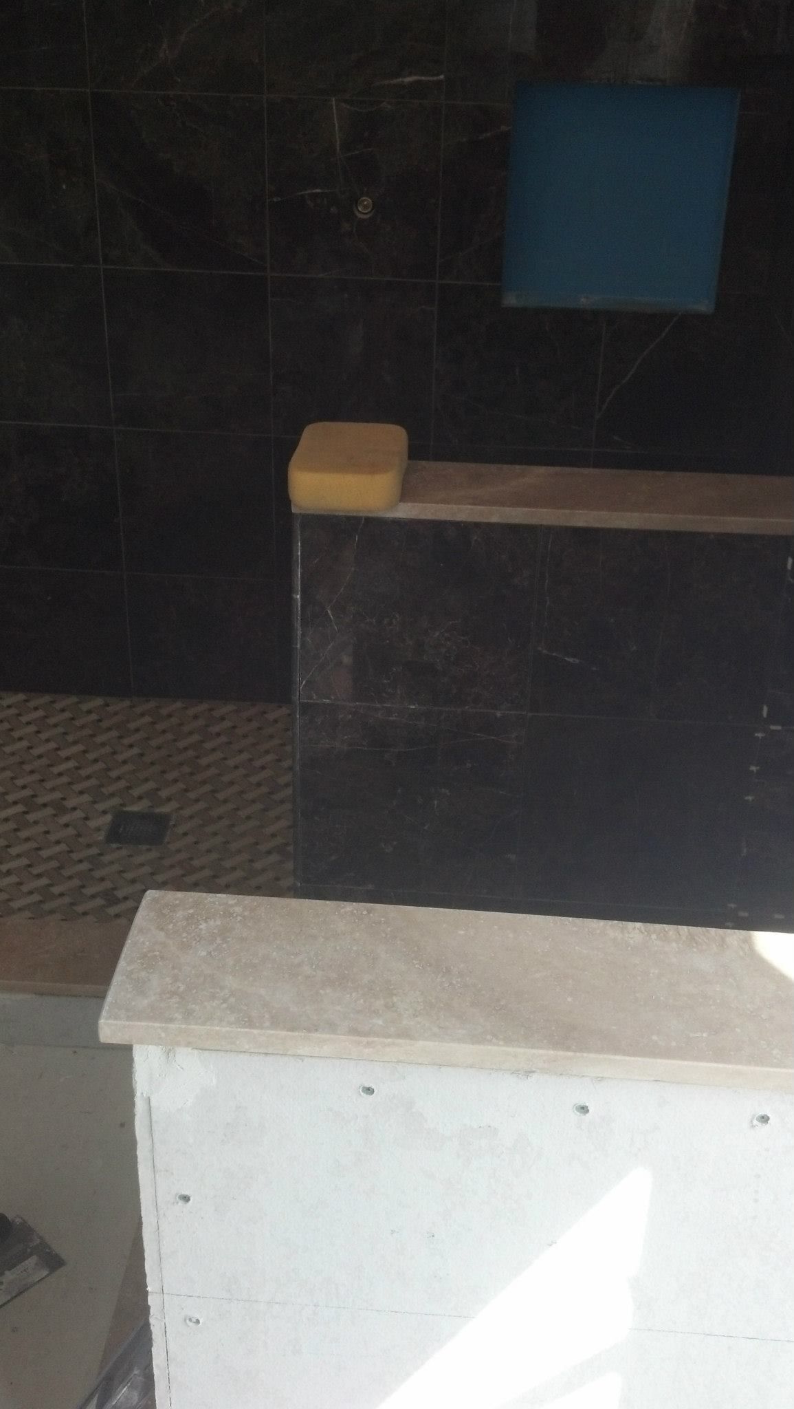 A sponge is sitting on top of a counter in a bathroom.