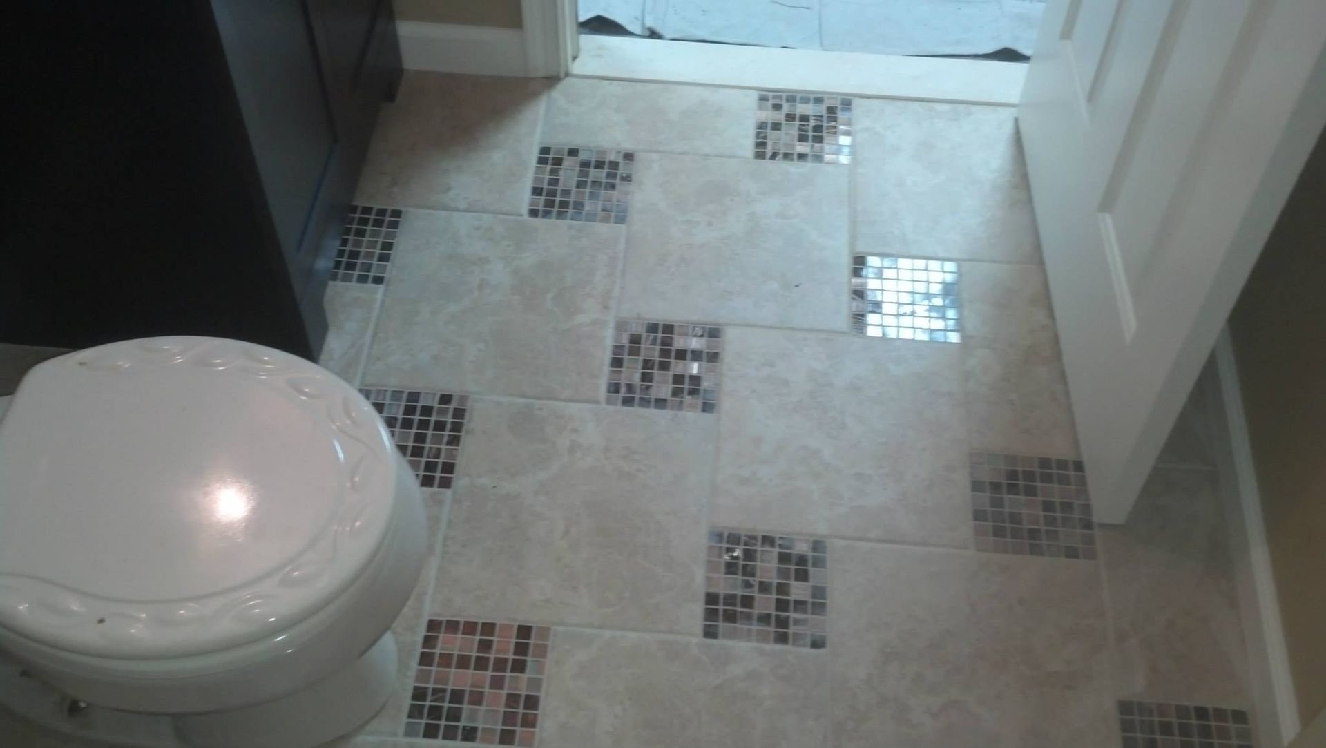 A toilet in a bathroom with a tiled floor