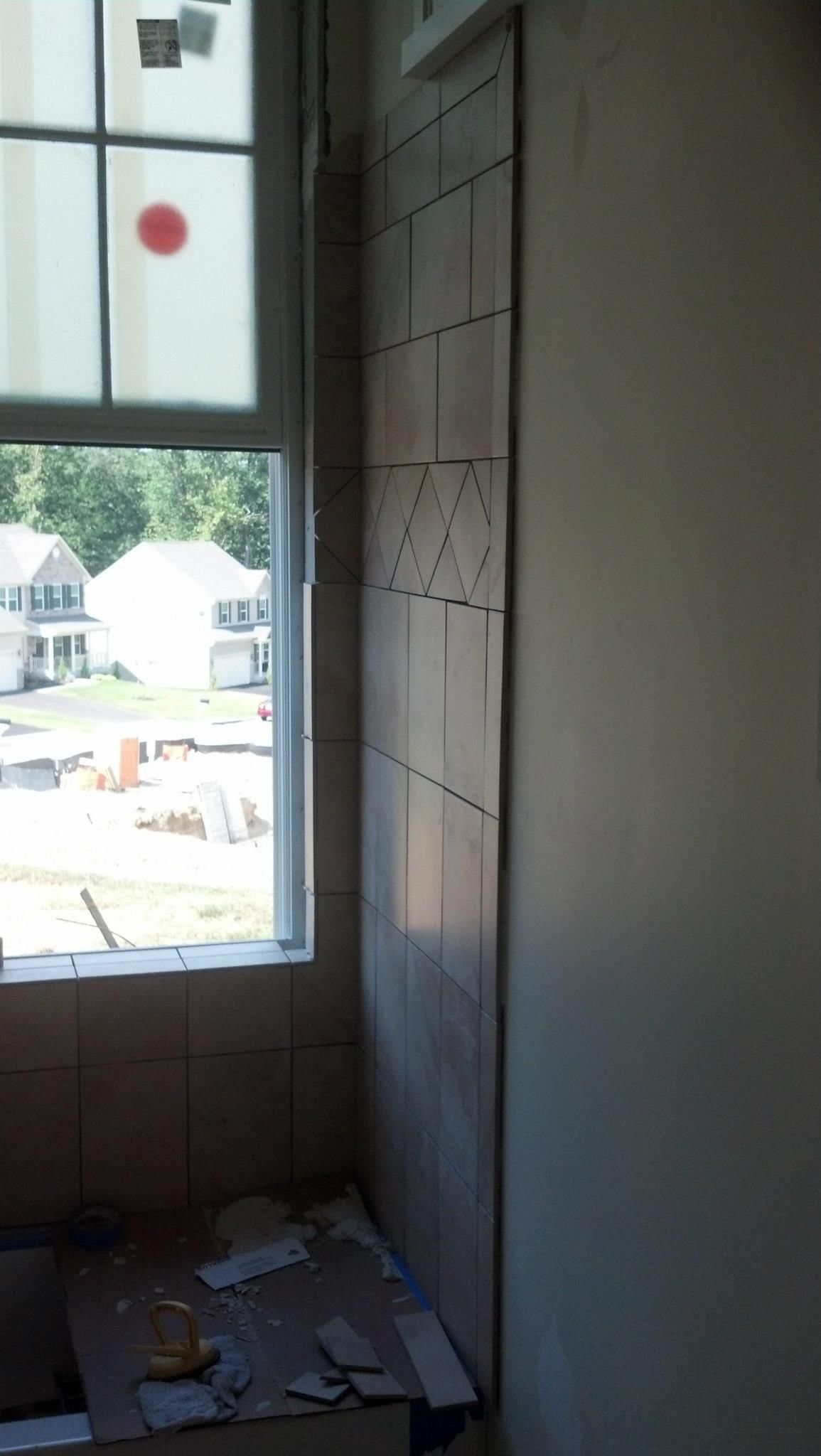 A bathroom with a window and a tiled wall