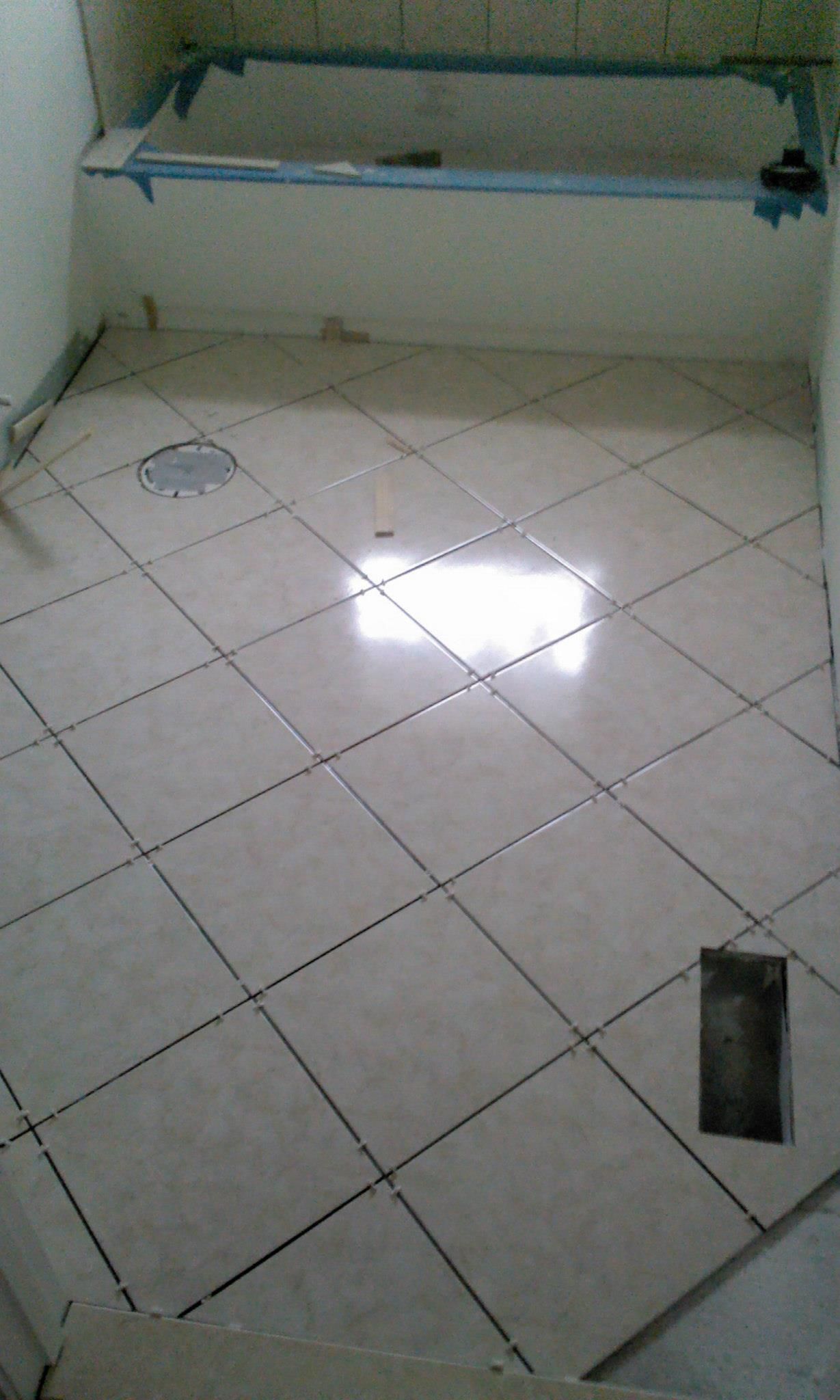 A bathroom with a tiled floor and a bathtub.