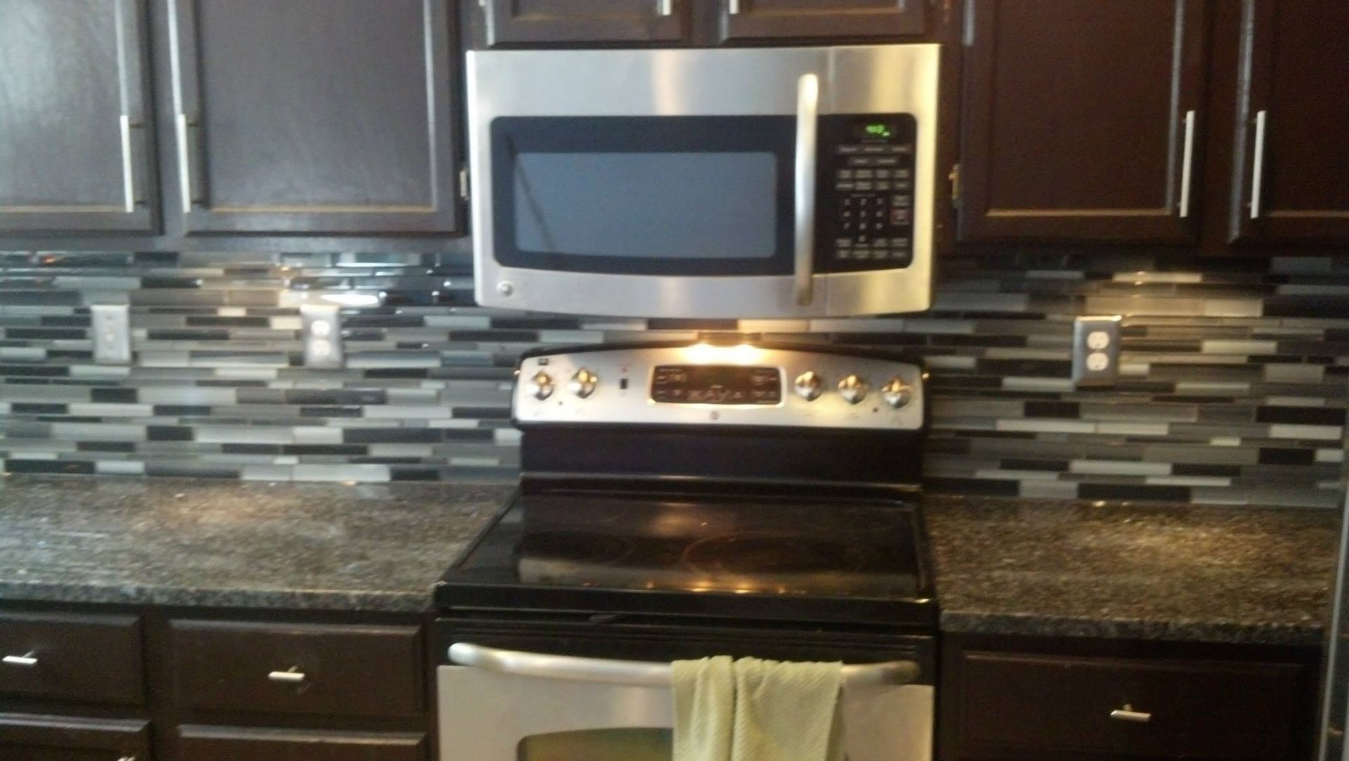 A kitchen with a stove top oven and a microwave