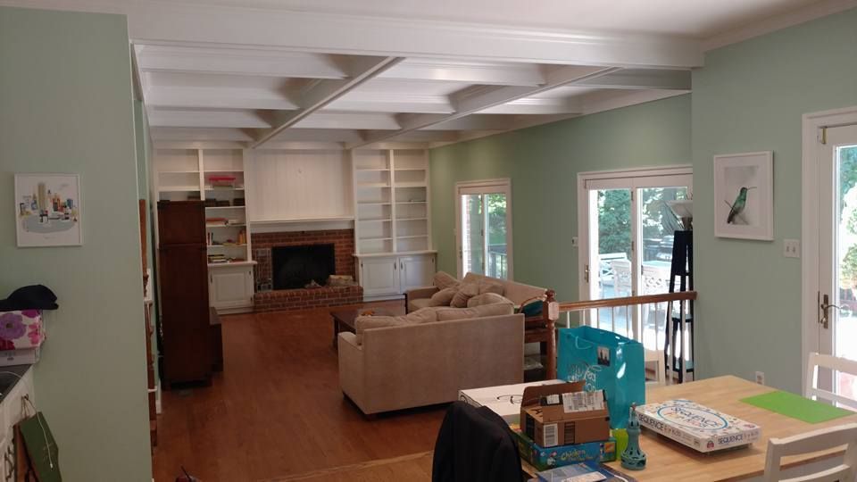 A living room with a couch , table , chairs and a fireplace.