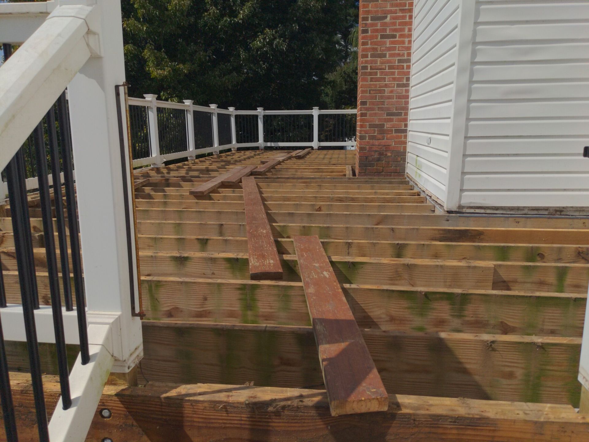 A wooden deck is being built in front of a white house