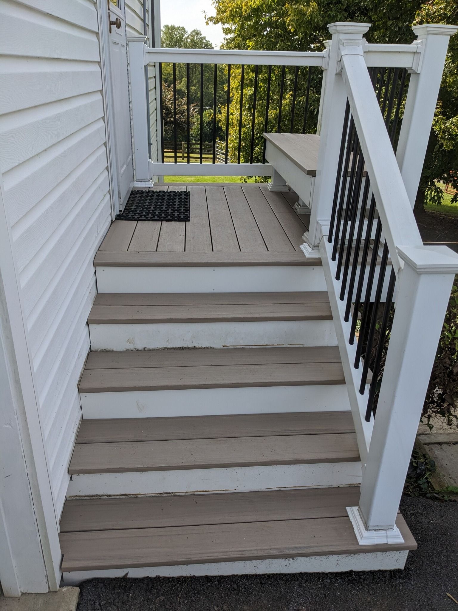 A set of stairs leading up to a deck with a white railing.