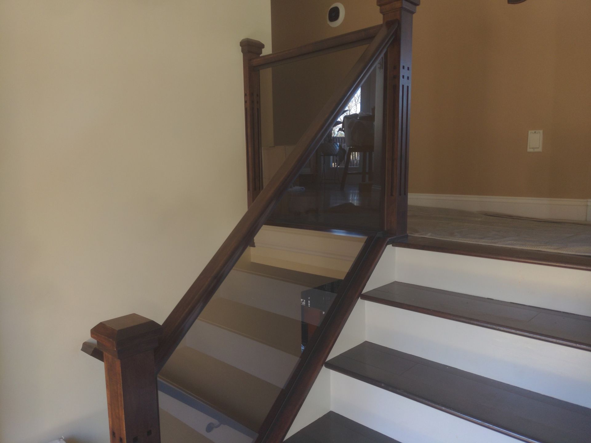 A staircase with a wooden railing and a glass railing