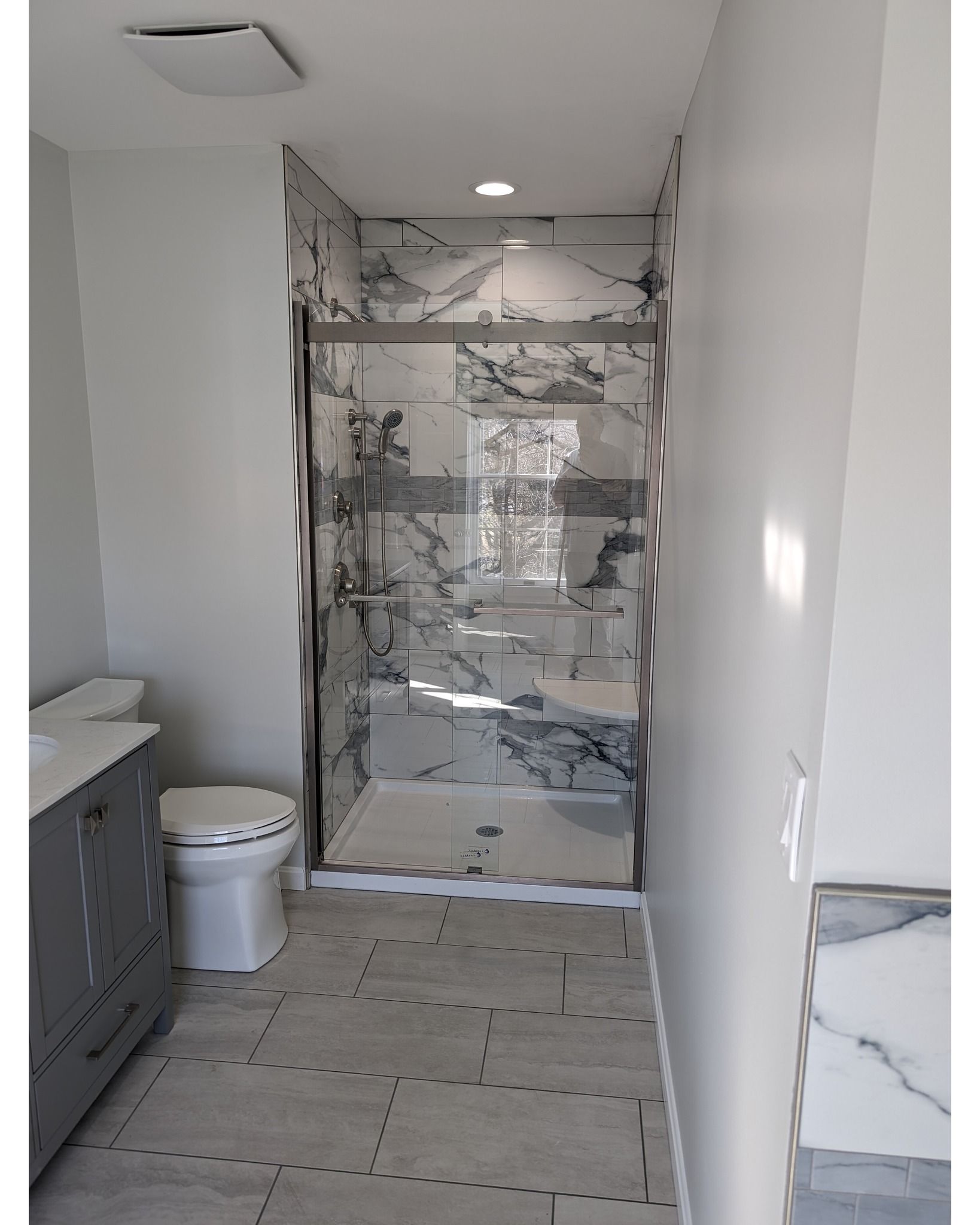 A bathroom with a toilet , sink , and walk in shower.