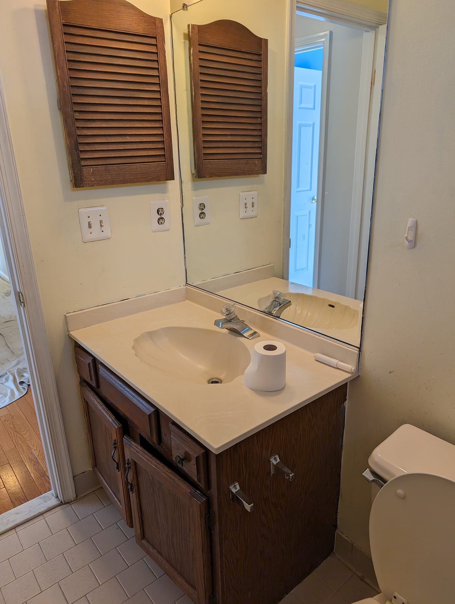 A bathroom with a sink , toilet and mirror.