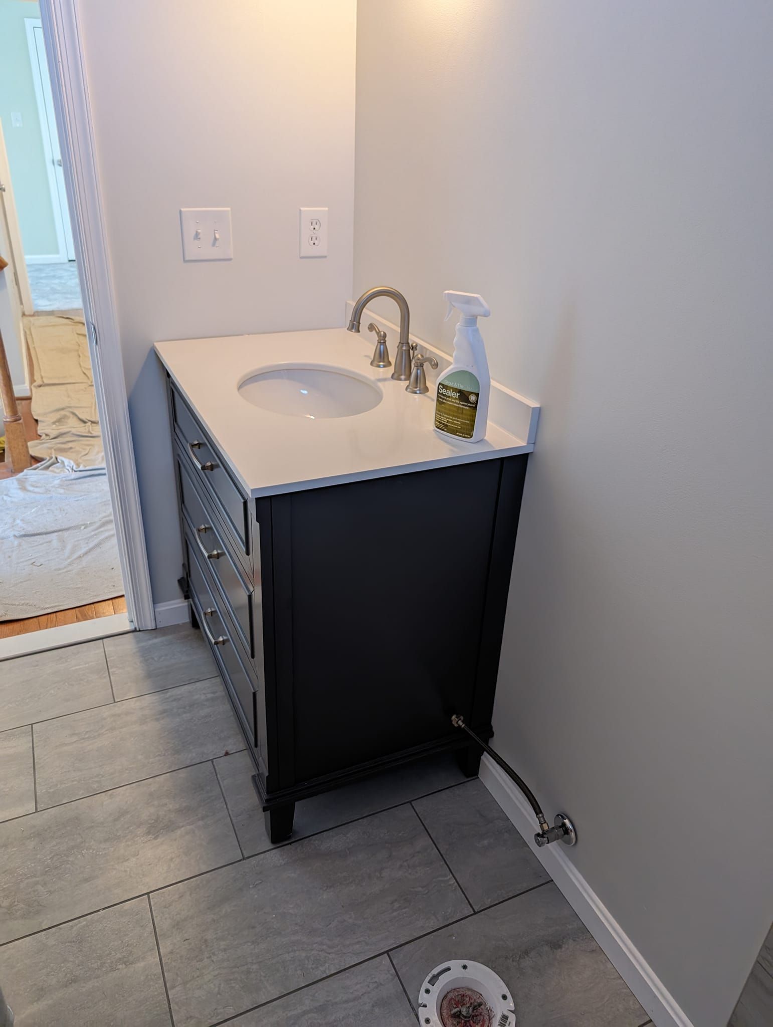 A bathroom vanity with a sink and a spray bottle on top of it.