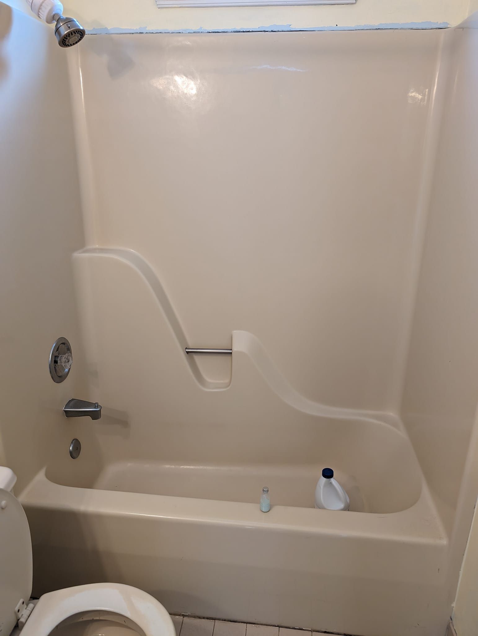 A bathroom with a bathtub , toilet and shower.