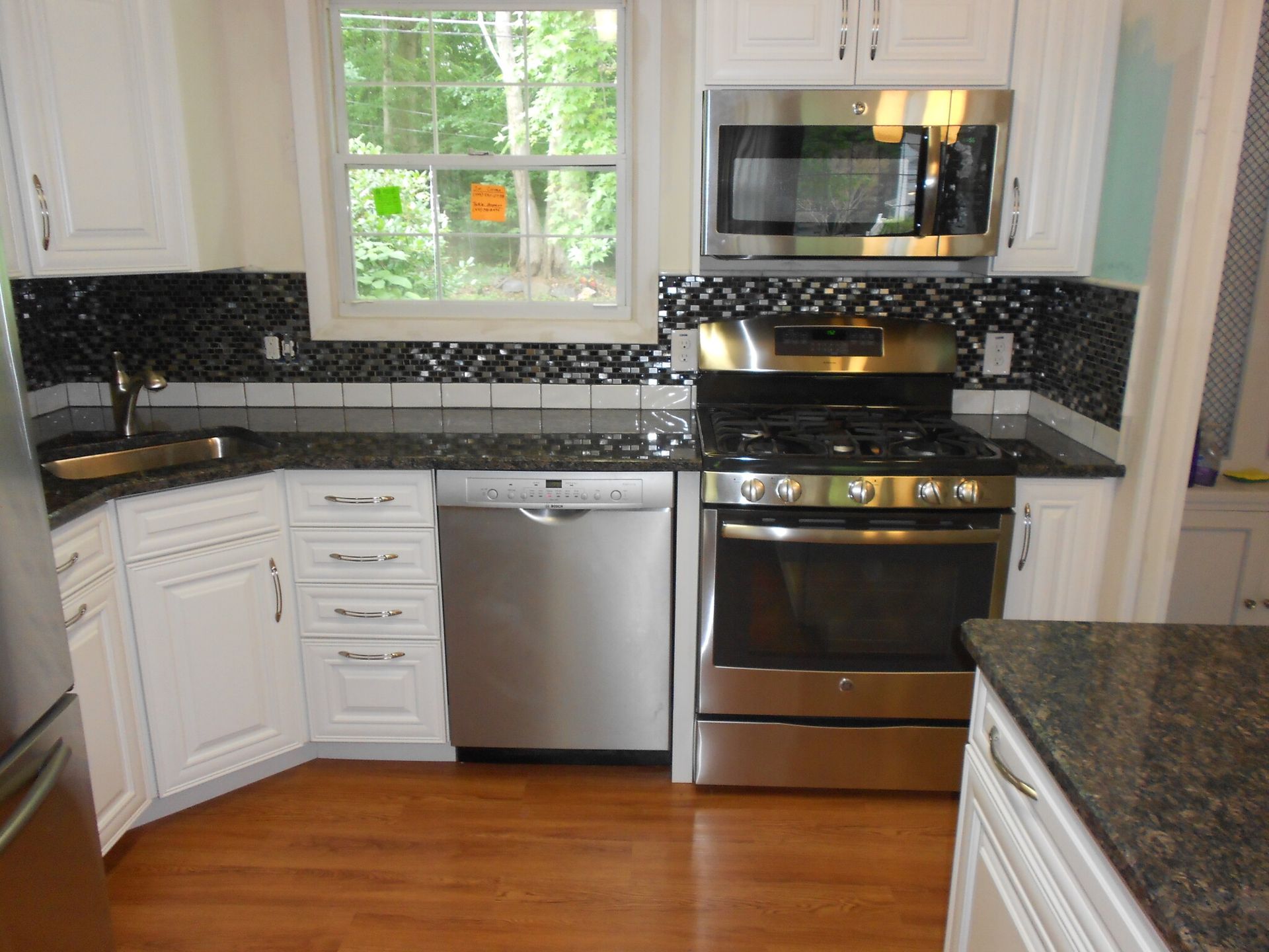 A kitchen with stainless steel appliances and white cabinets