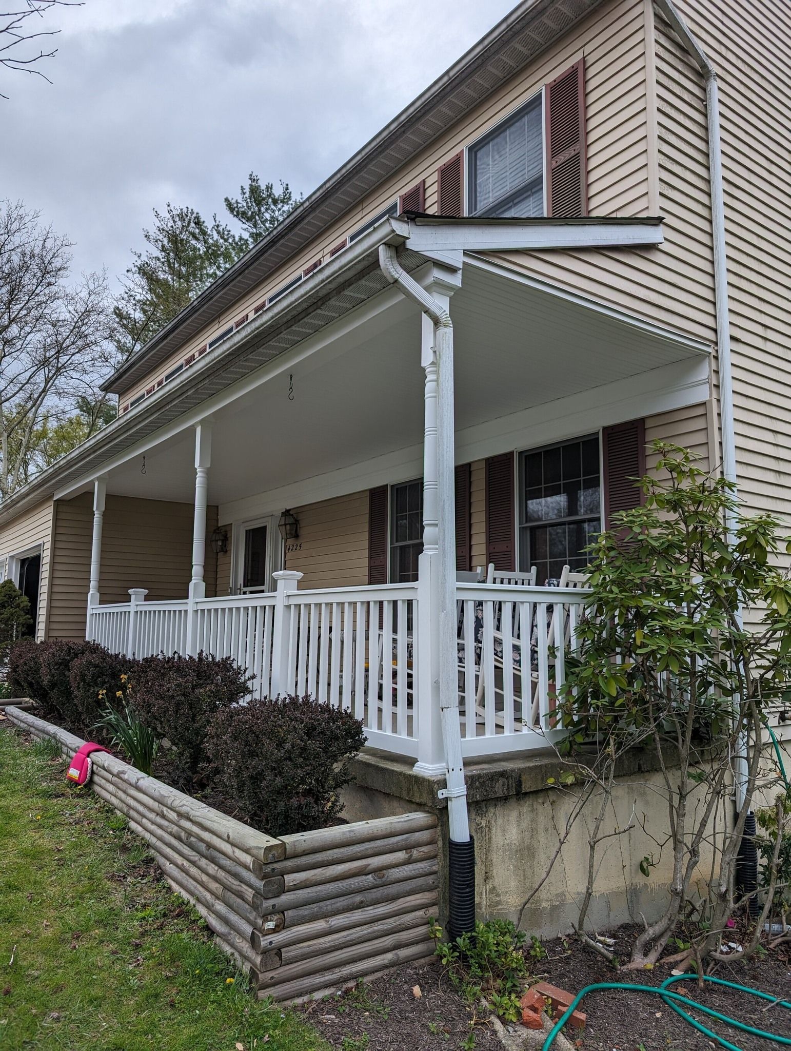 A house with a porch and a hose in front of it
