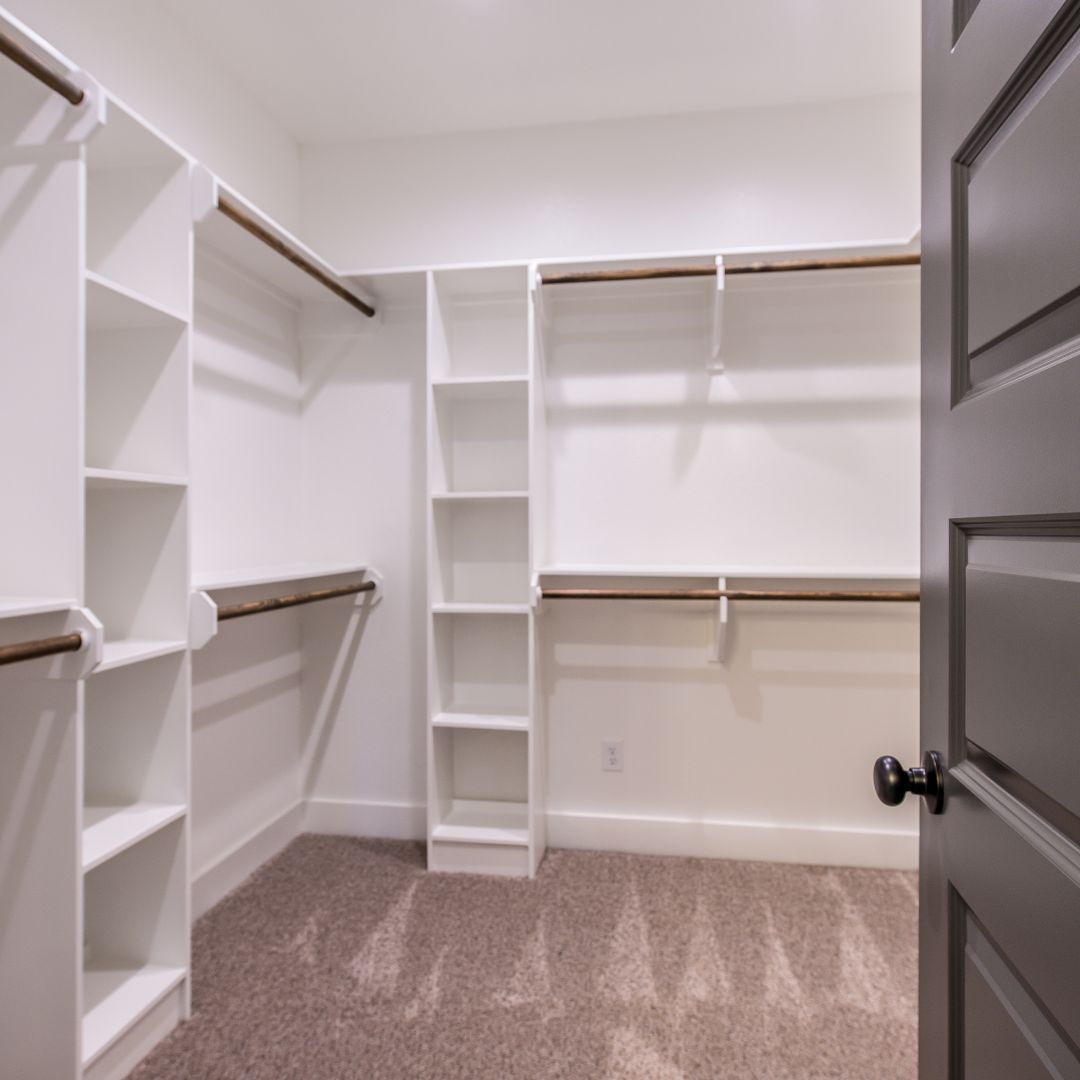 A walk in closet with lots of shelves and hangers