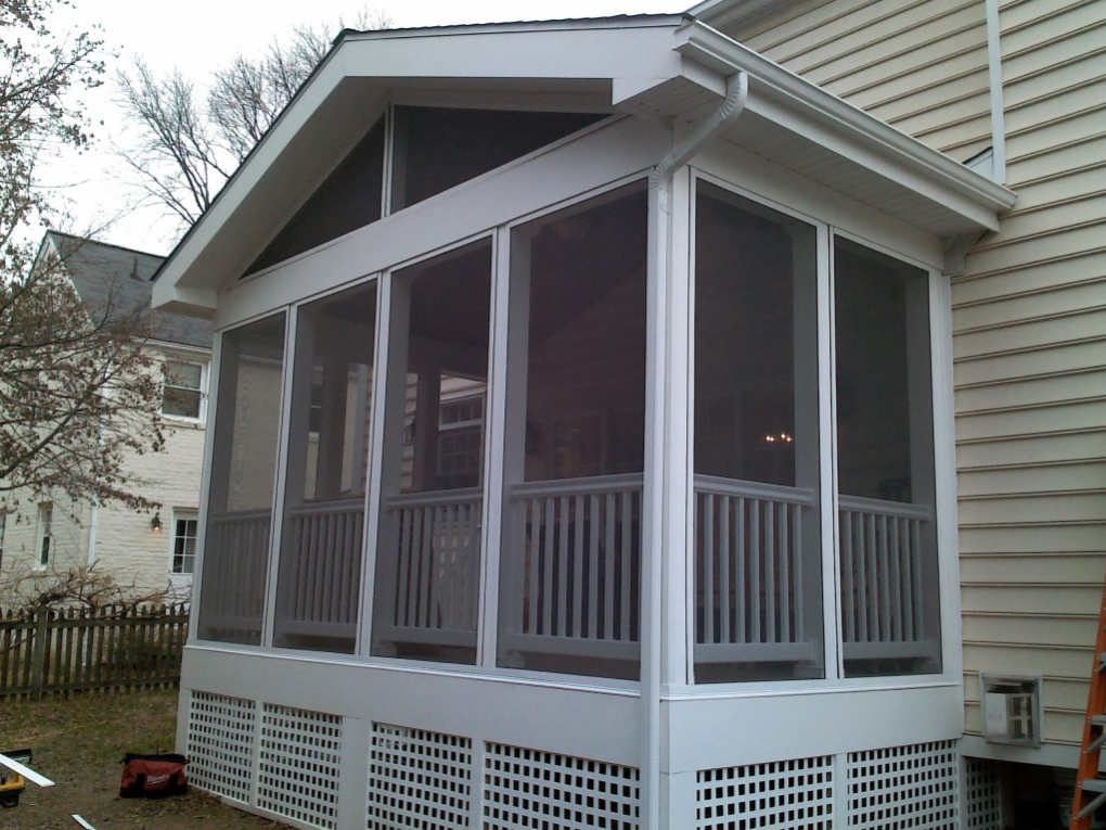 A screened in porch on the side of a house