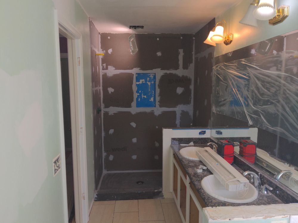 A bathroom with two sinks , a shower and a mirror.