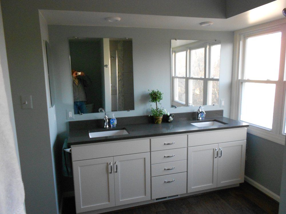 A bathroom with two sinks and a large mirror