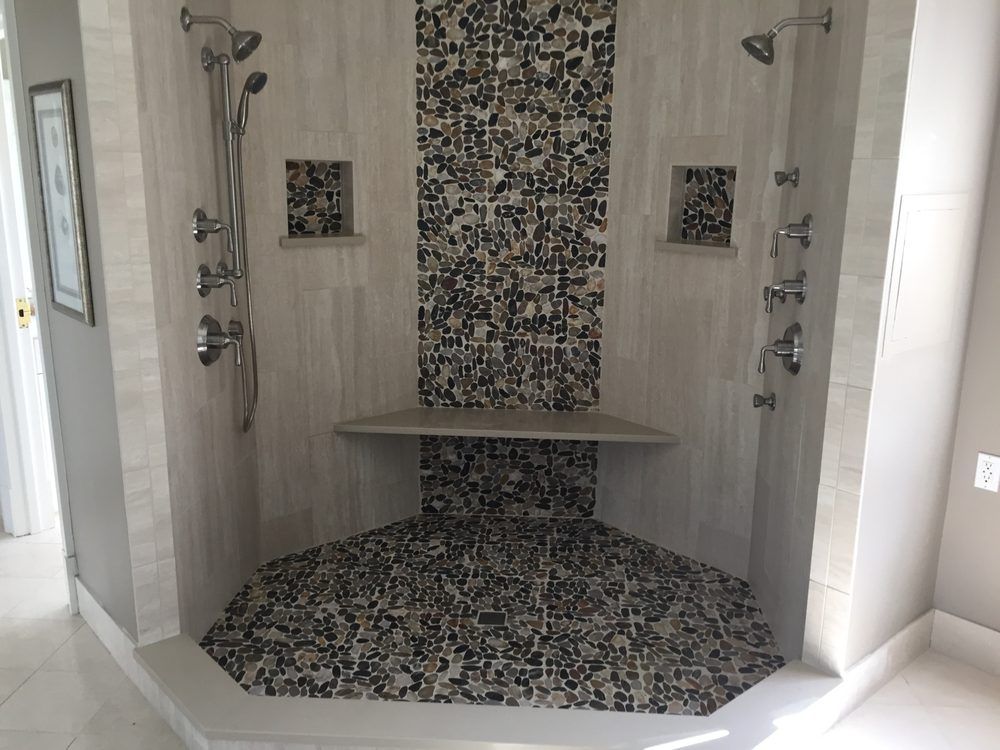 A bathroom with a walk in shower and a bench