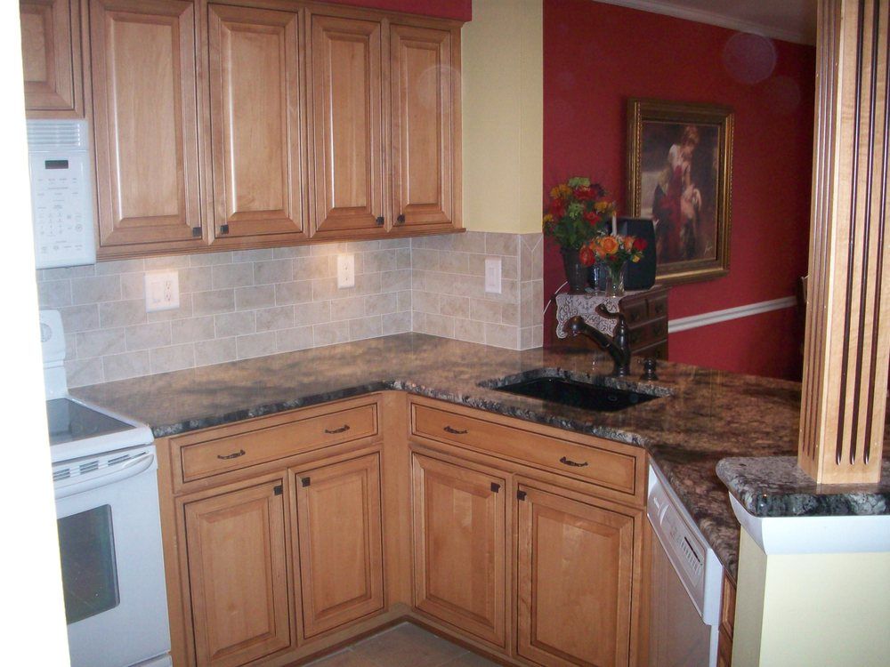 A kitchen with wooden cabinets and granite counter tops