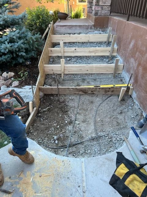 A man is working on a set of concrete steps.