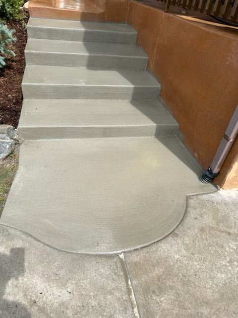 A set of concrete stairs leading up to a house.