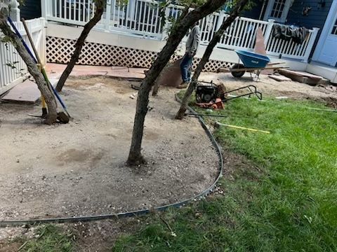 A man is working on a lawn in front of a house.