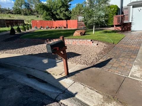 A mailbox is sitting on the sidewalk in front of a house.