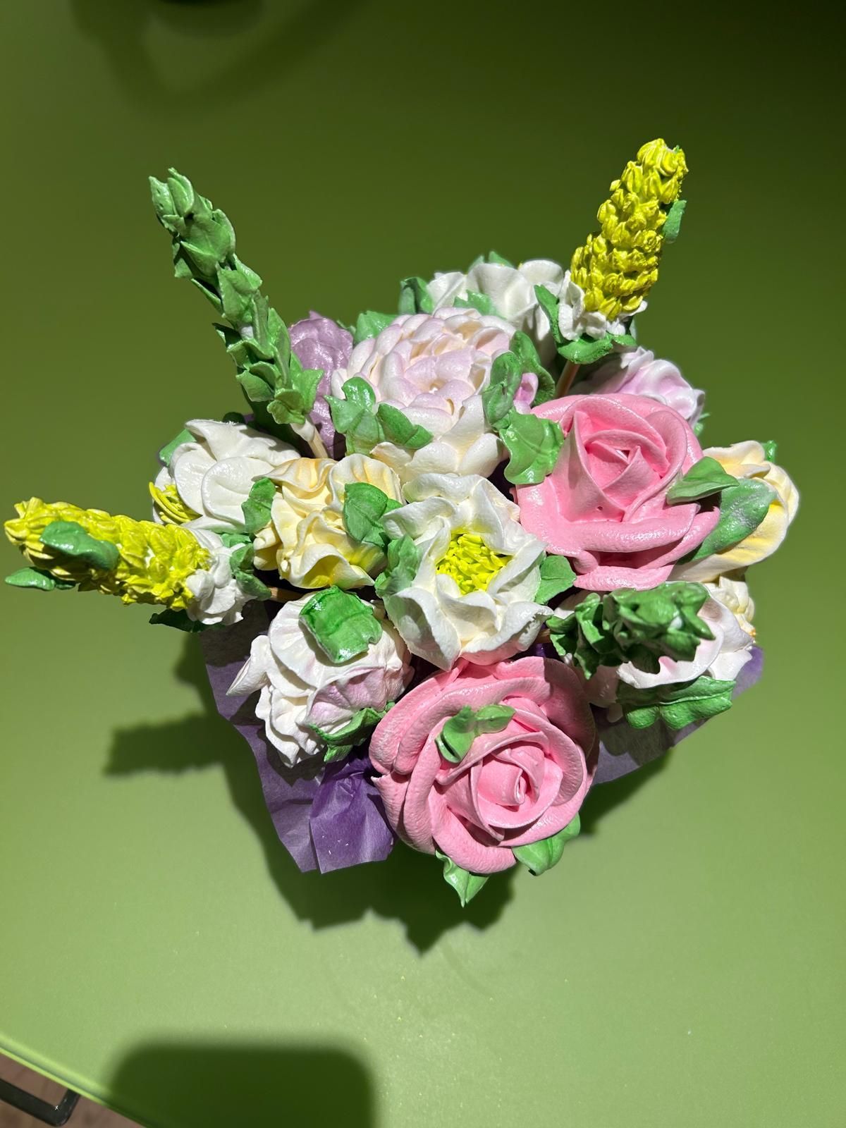 Rosa-weißer Blumenstrauß mit gelben Akzenten auf grünem Hintergrund