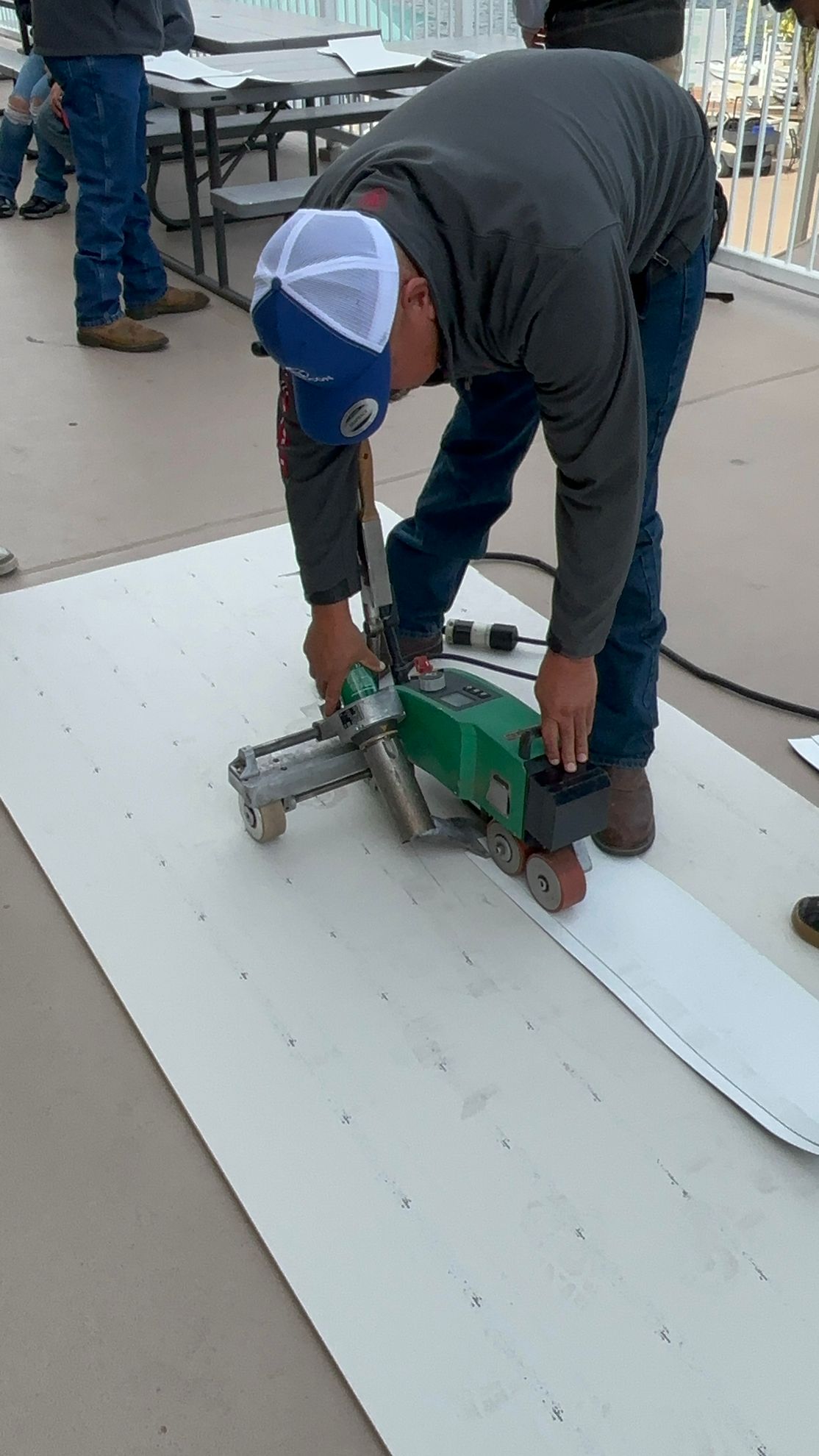 A man is using a machine to cut a piece of paper.