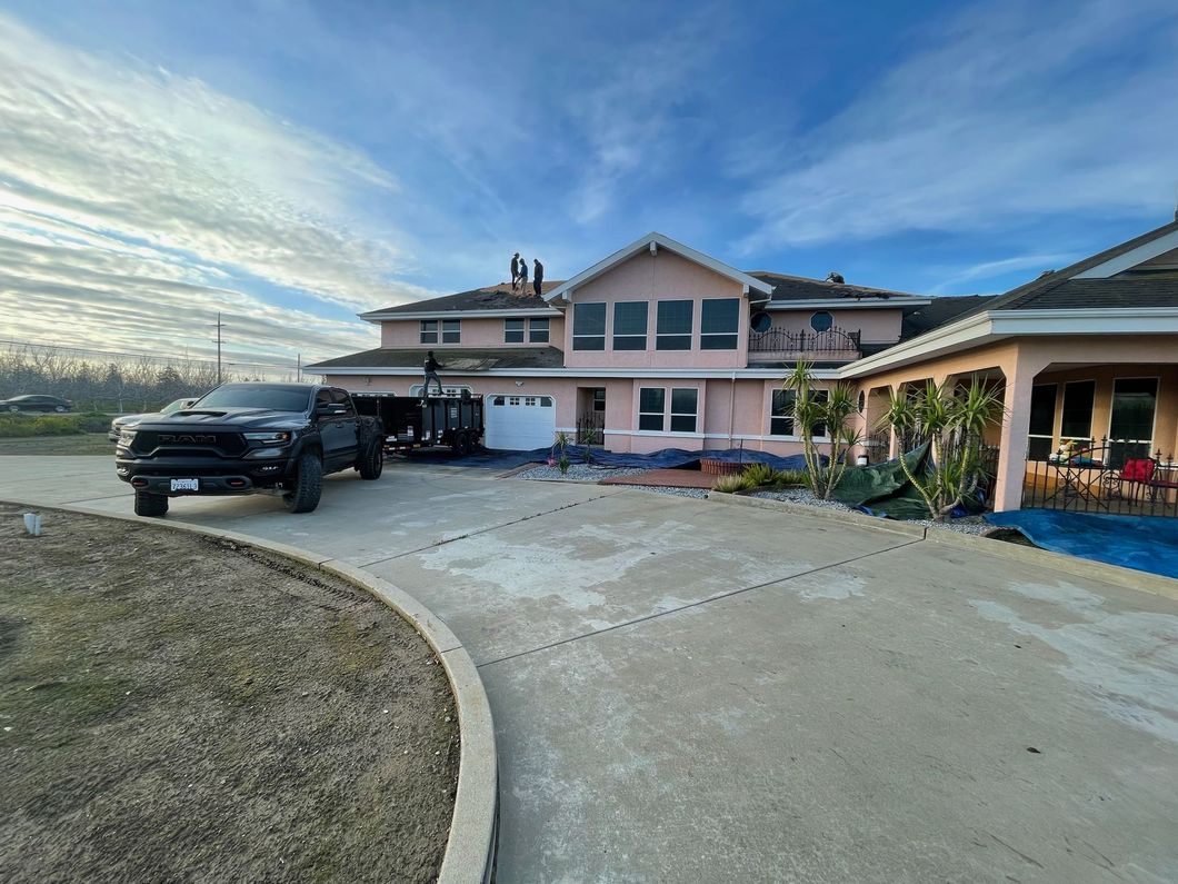 A truck is parked in front of a large house.