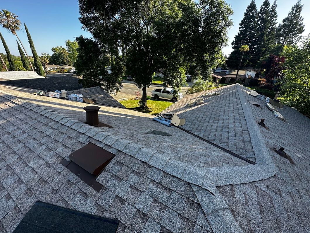 An aerial view of a roof with trees in the background