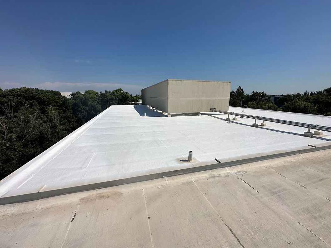 A large white roof with trees in the background