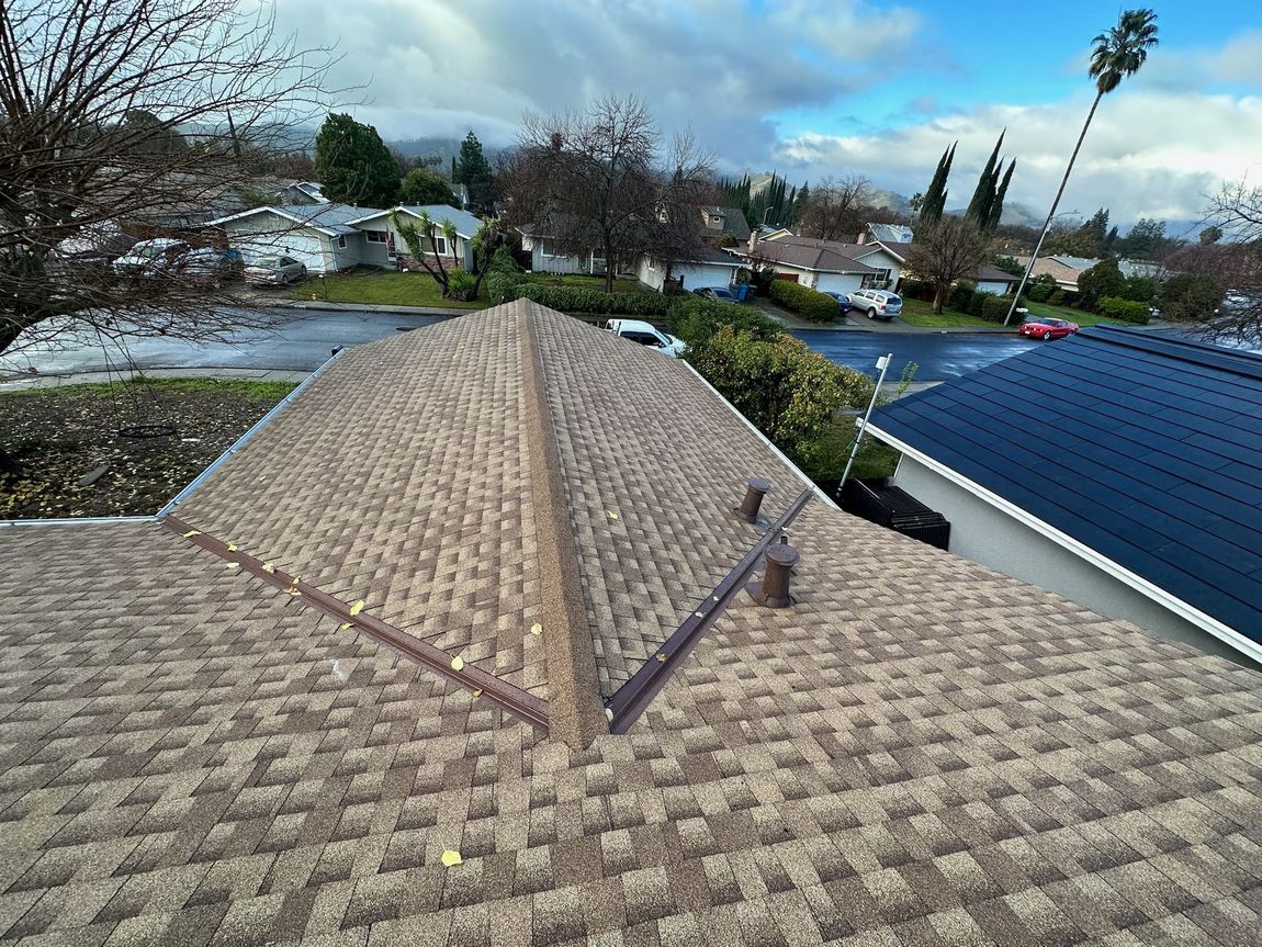 The roof of a house with a solar panel on it.