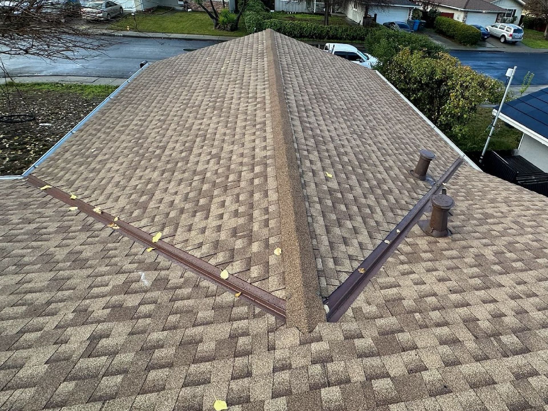 An aerial view of a roof of a house in a residential area.