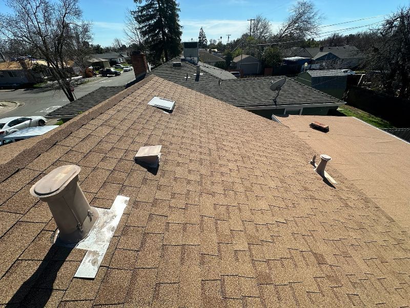 A roof with a chimney on it and a lot of shingles on it.