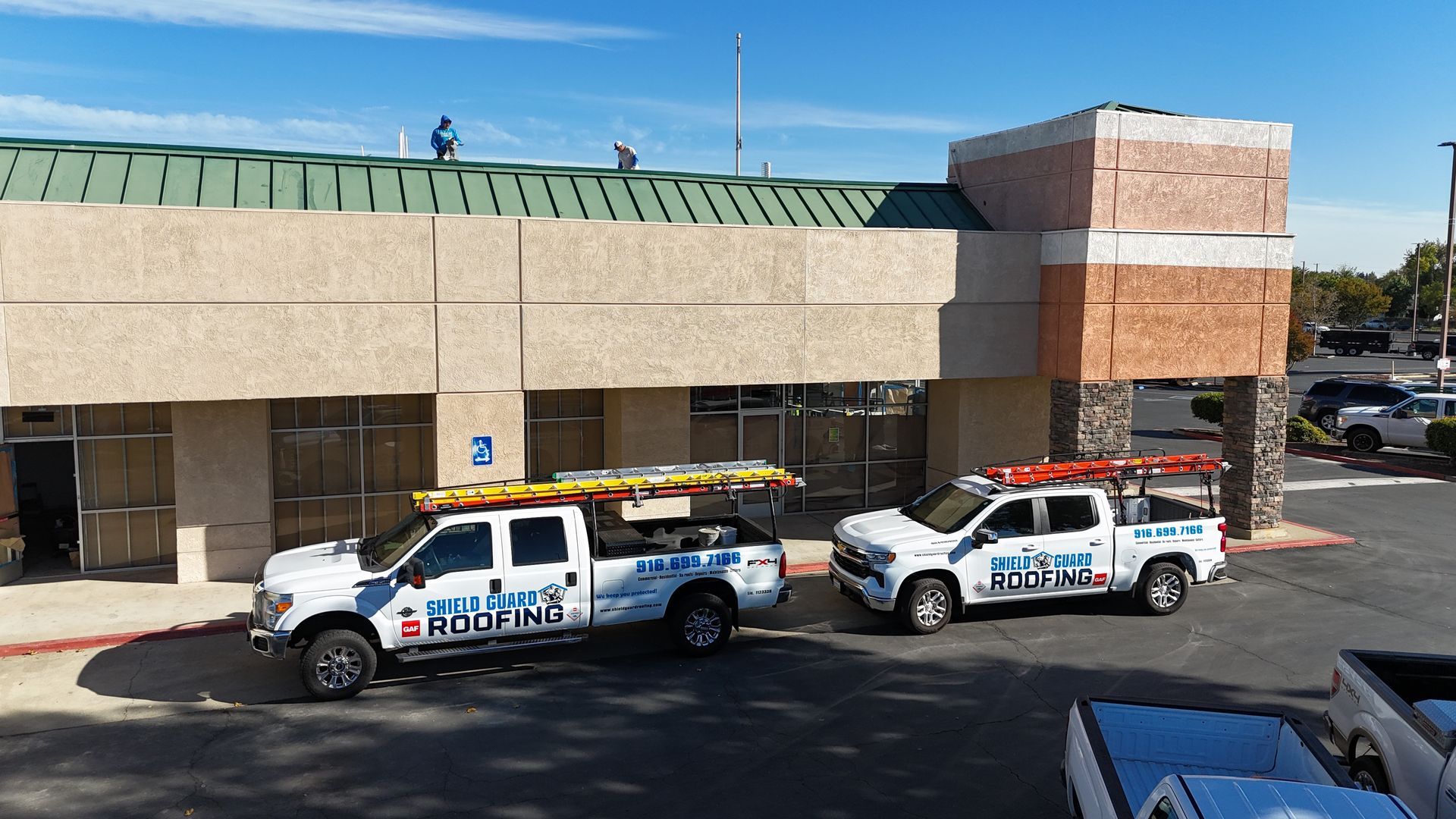 Two trucks are parked in front of a building.