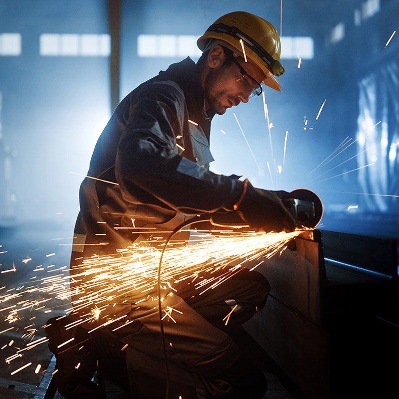 Worker cutting metal cube