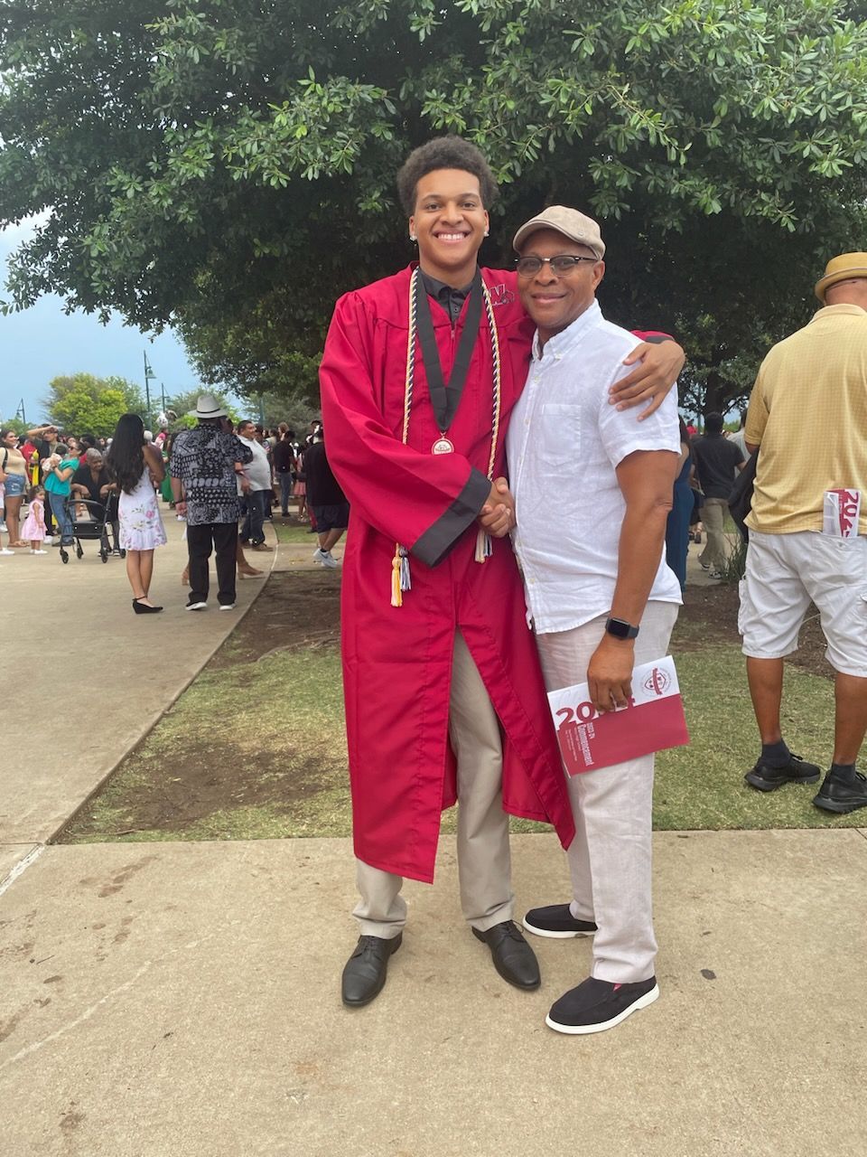 a man in a purple shirt is decorating a christmas tree in a living room .