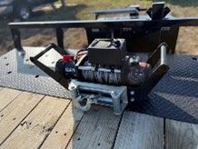 A winch is sitting on top of a wooden deck.