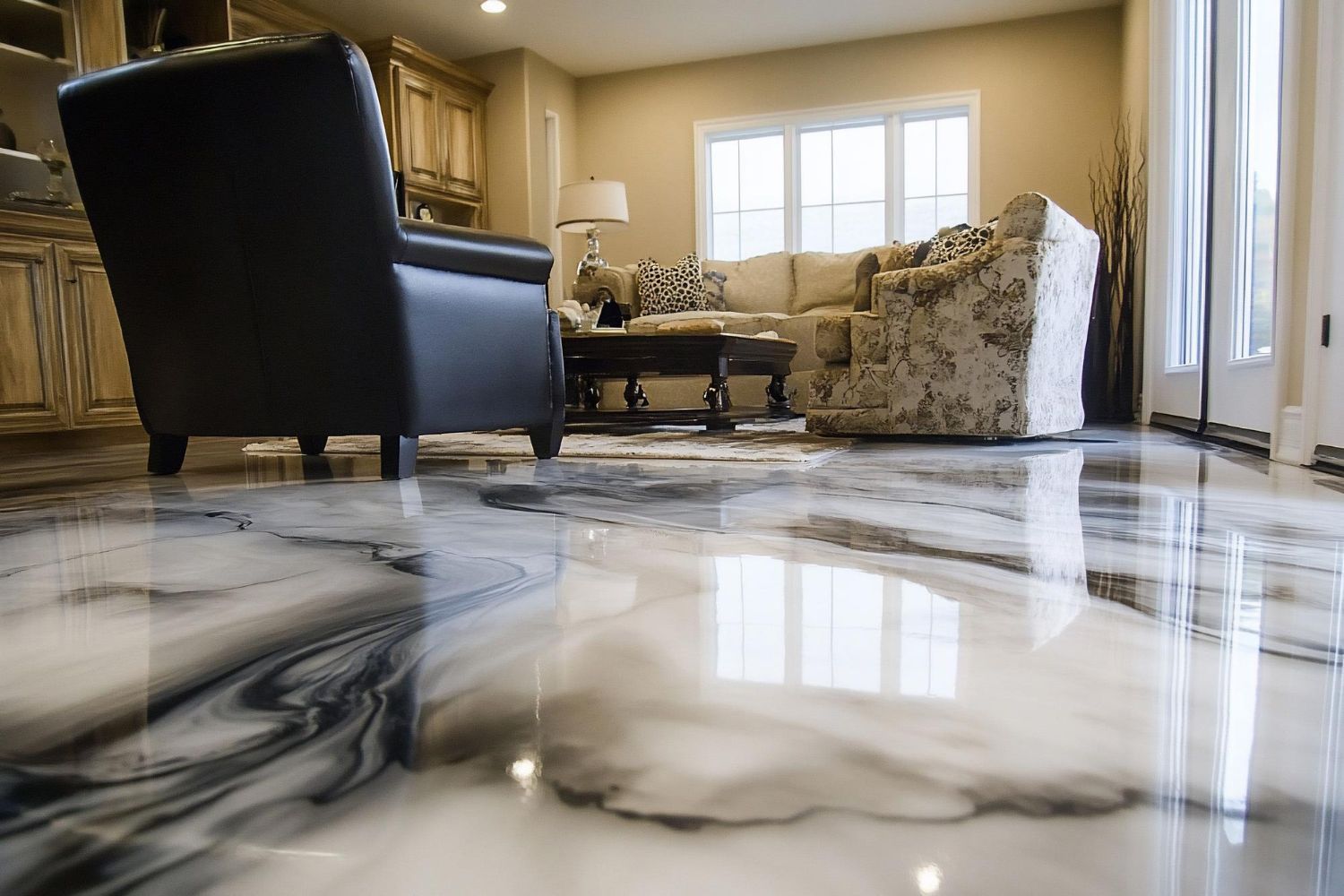 Shiny, marbled epoxy floor reflecting a living room with tan walls, cream sofa, and black leather chair.
