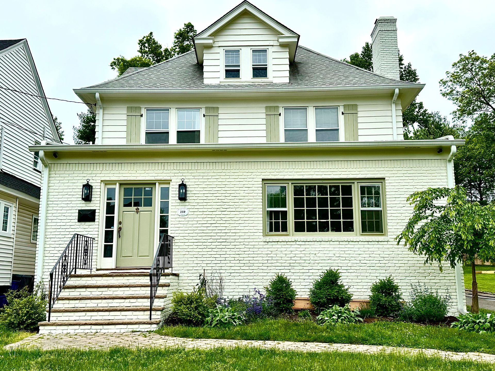 A white house with stairs leading up to the front door