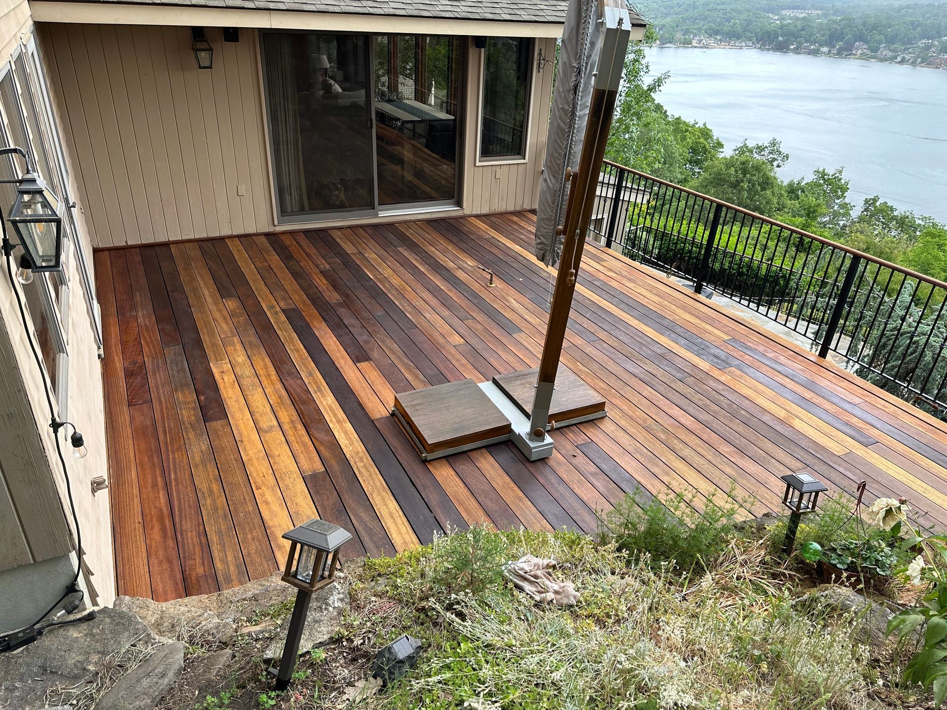 A large wooden deck with a view of a lake.