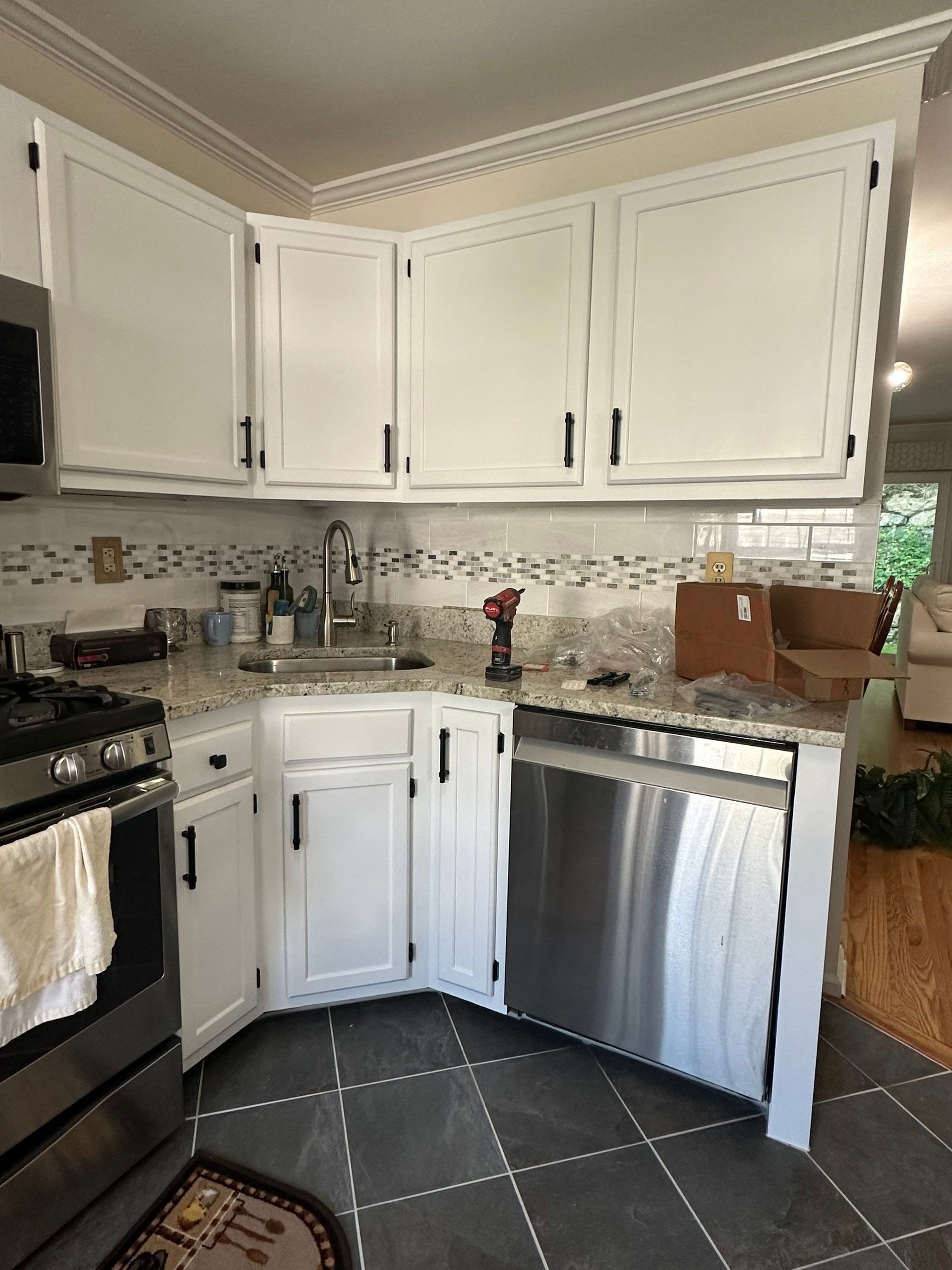 A kitchen with white cabinets and stainless steel appliances