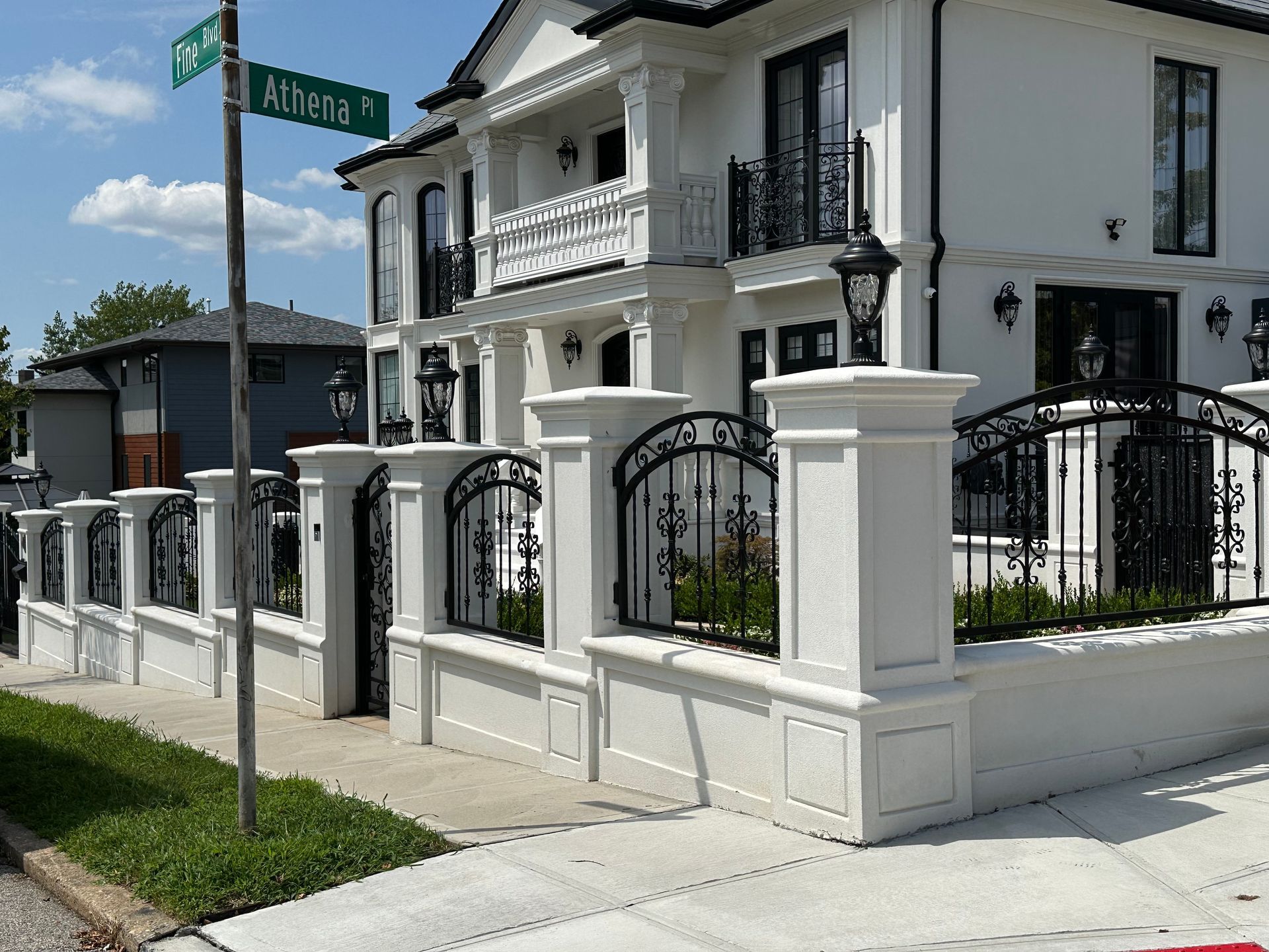A large white house with a fence and a street sign that says alterra