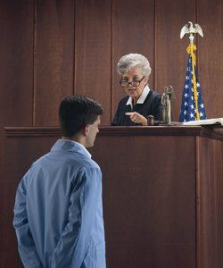 judge speaking to handcuffed man in court