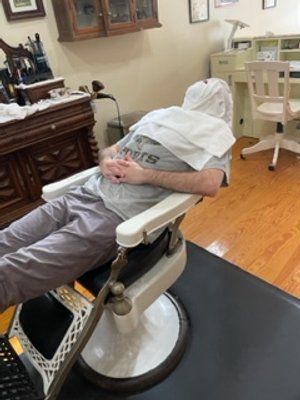 Guy In Blue Shirt Towel Shave — New Orleans, LA — Bad Habit Barber Shop