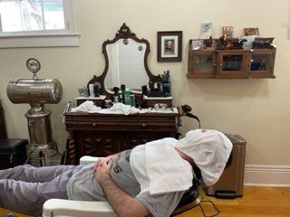 Guy In Grey Shirt Towel Shave — New Orleans, LA — Bad Habit Barber Shop