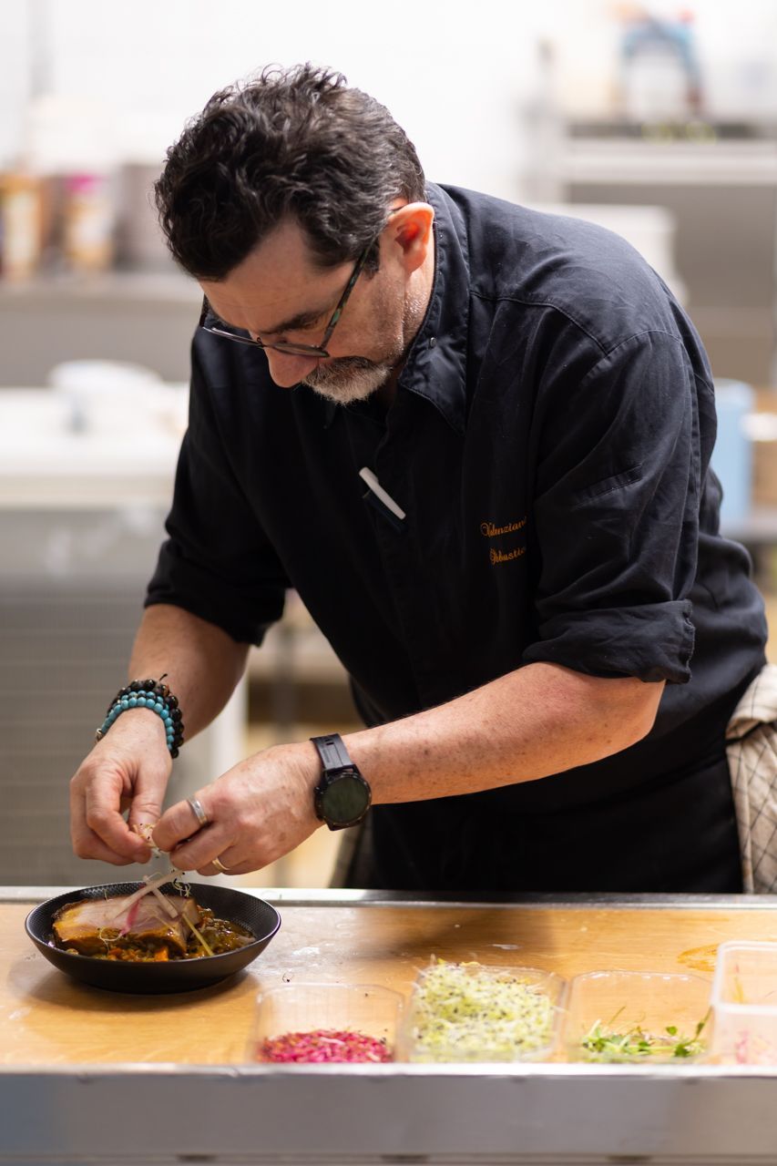 Un homme prépare de la nourriture dans une cuisine.