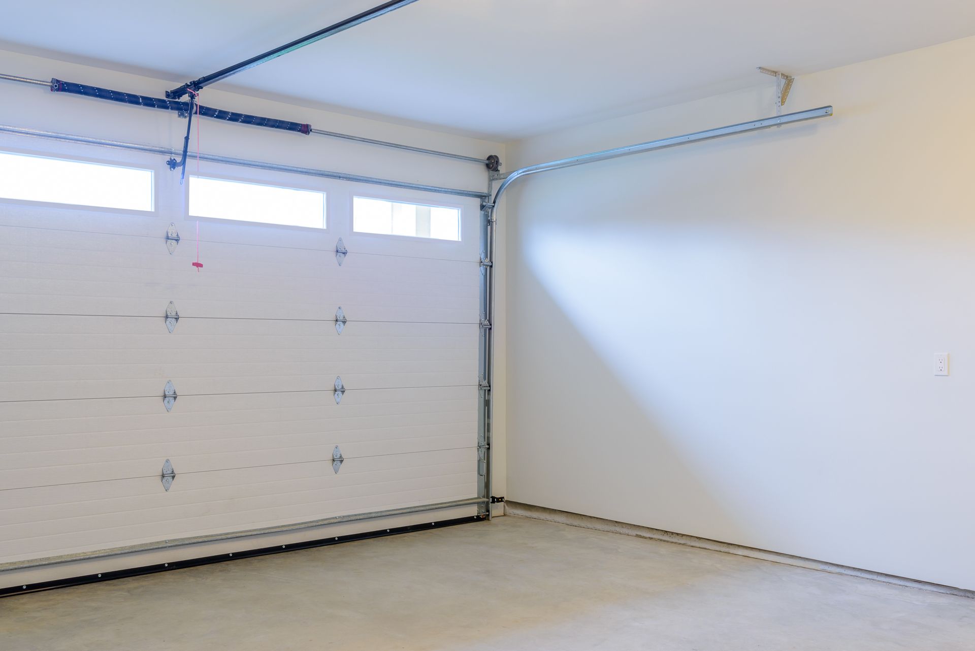 Empty garage with white door and walls.